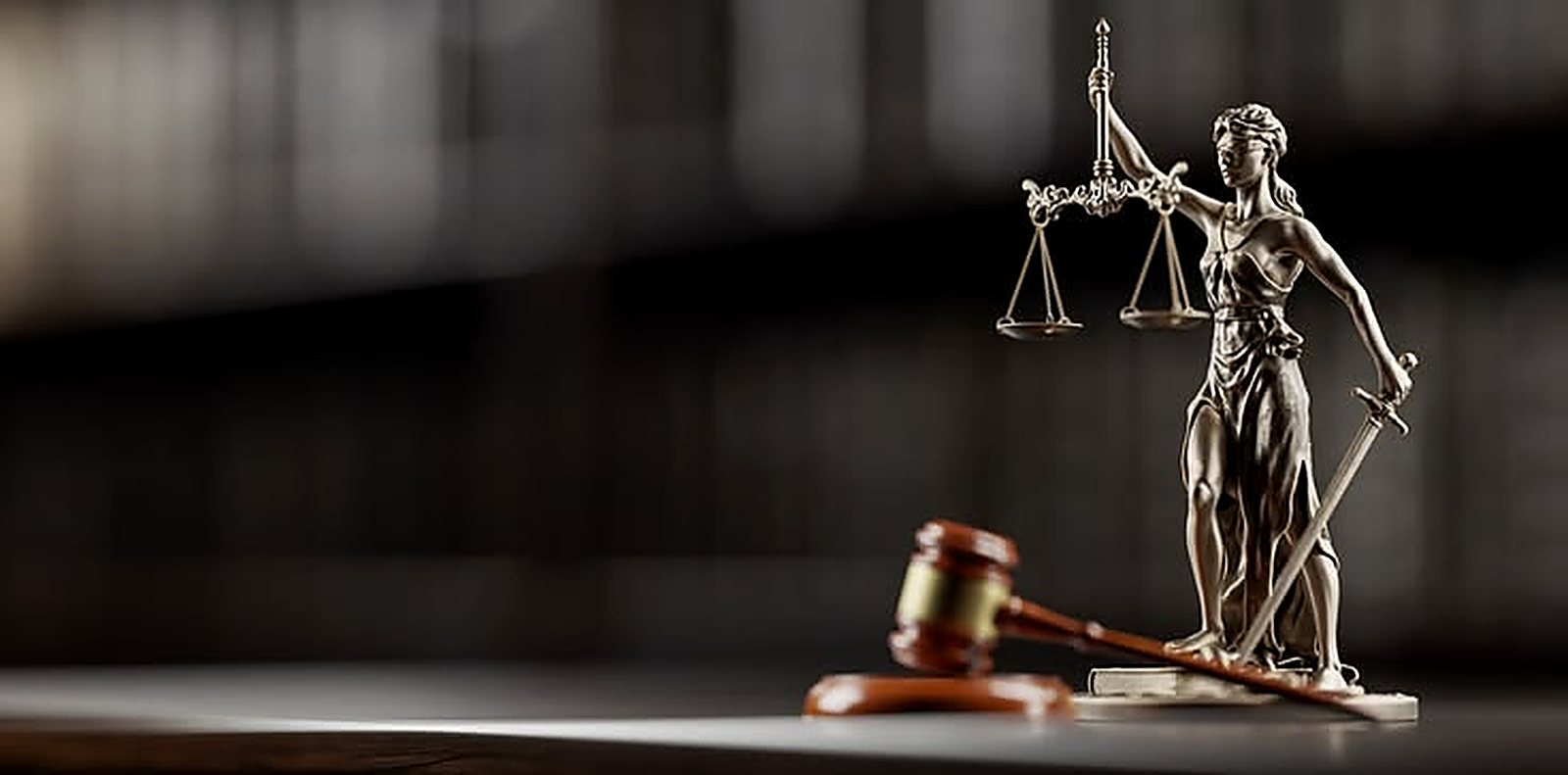 Statue of Lady Justice holding the scales, beside a wooden gavel